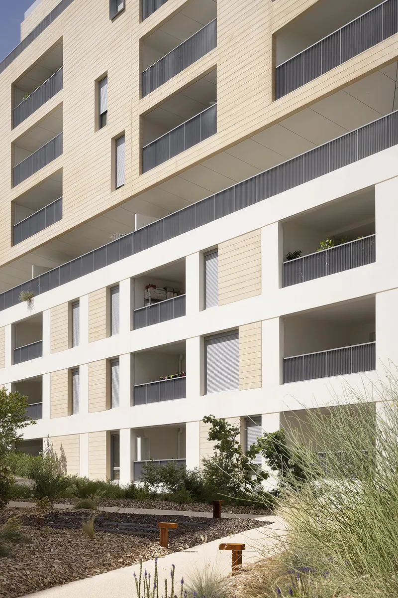Vue verticale d'un angle du bâtiment : superposition des terrasses en gradins et des balcons filants.